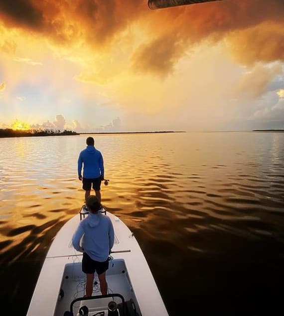 An image of Captain Justin Bachert with an angling guest on a full day charter at sunset with Hot Water Fishing of the florida keys. 
